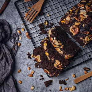 pexels-photo-9810299-9810299 Sliced chocolate loaf cake with nuts on a wire rack, offering a delectable dessert option.