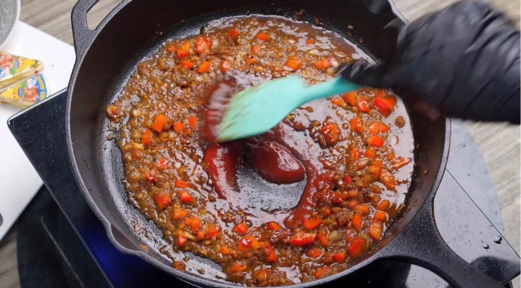 Add marmite and tomato puree Marmite and tomato purée being added to the creamy sauce in a hot skillet, ready to be stirred in.