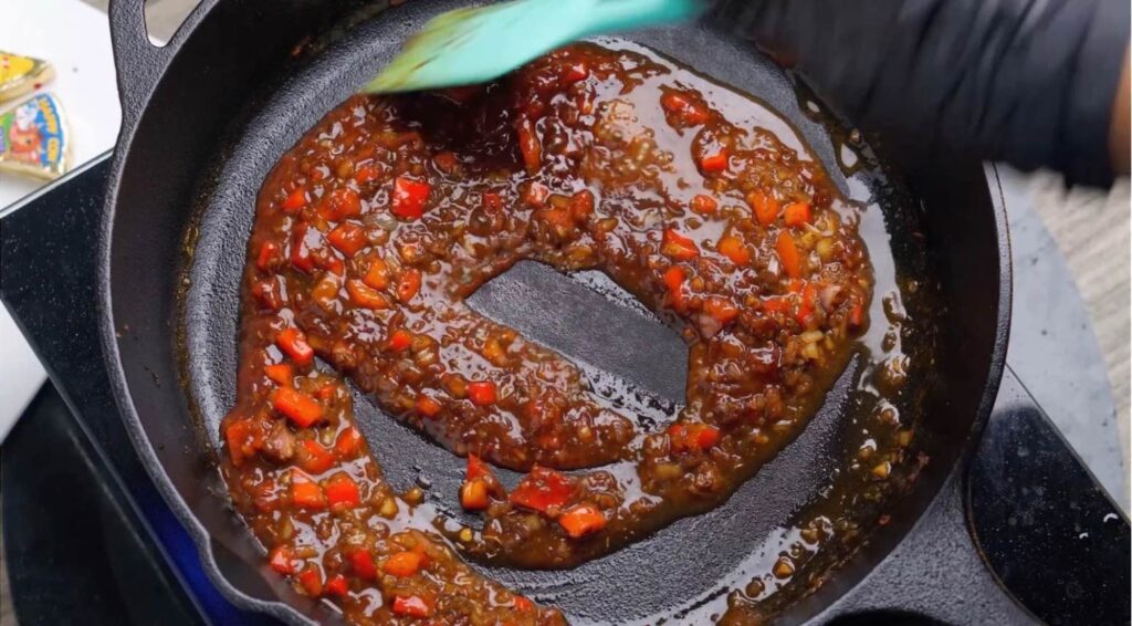 Add marmite and tomato puree Marmite and tomato purée being added to the creamy sauce in a hot skillet, ready to be stirred in.