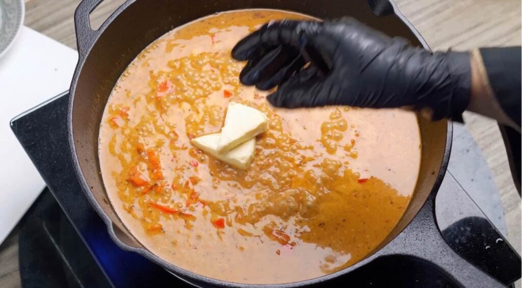 Make it creamy Heavy cream and cheese wedges being poured into the simmering skillet sauce