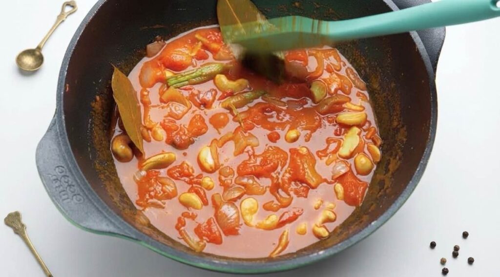 Make the sauce Makhani sauce simmering in a covered pan as tomatoes and onions cook until soft and mushy.