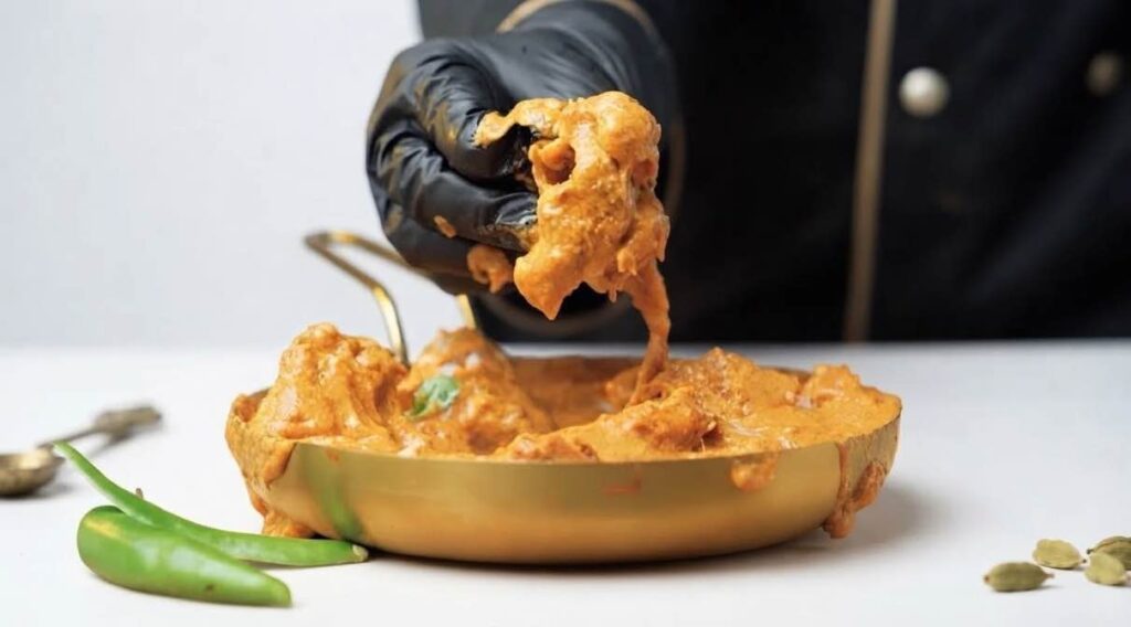 Butter chicken masala Homemade creamy butter chicken masala served in a bowl with warm naan