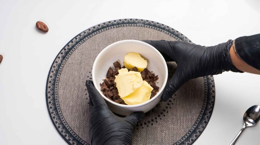 Melting the Chocolate and Butter Dark chocolate and butter melted together in a bowl and left to cool slightly.