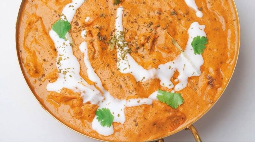 Butter chicken masala Creamy butter chicken masala garnished with fresh cilantro and a drizzle of cream