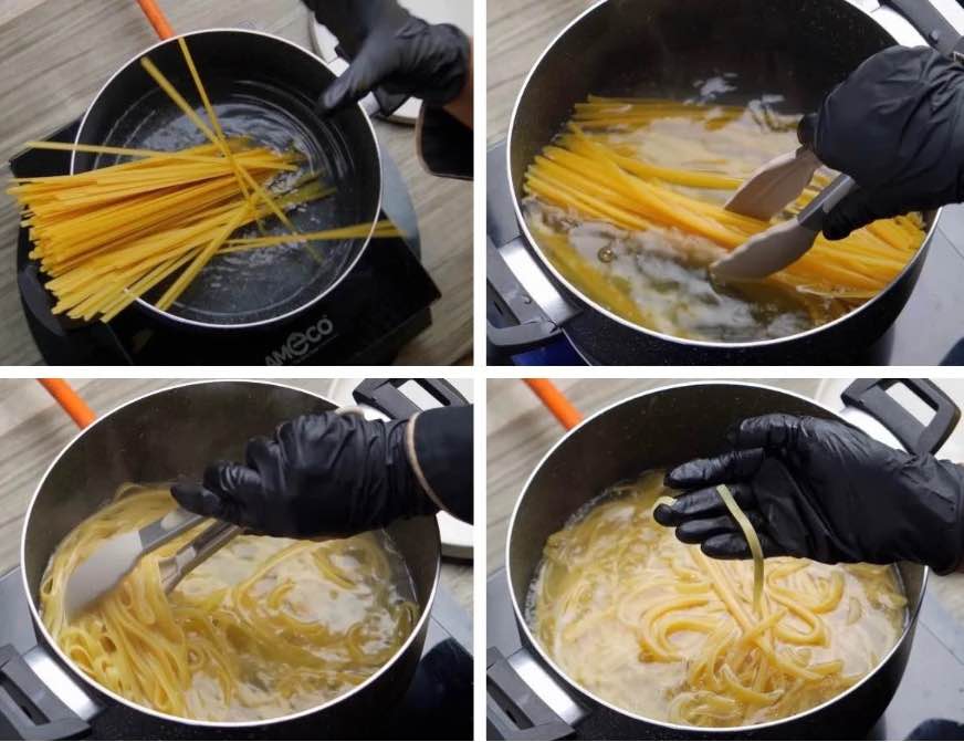 Cook the fettuccine Fettuccine pasta being placed into a large pot of boiling water, with steam rising from the pot.