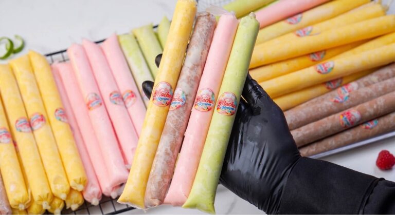 A pile of frozen Creamy Es Mambo icy poles inside small plastic tubes showing colorful marbled white chocolate designs.